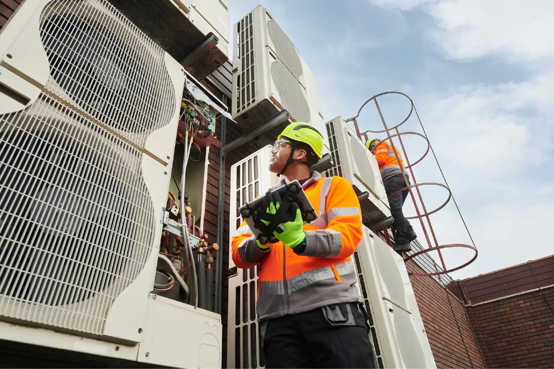 Technician servicing rooftop air-conditioning condenser units
