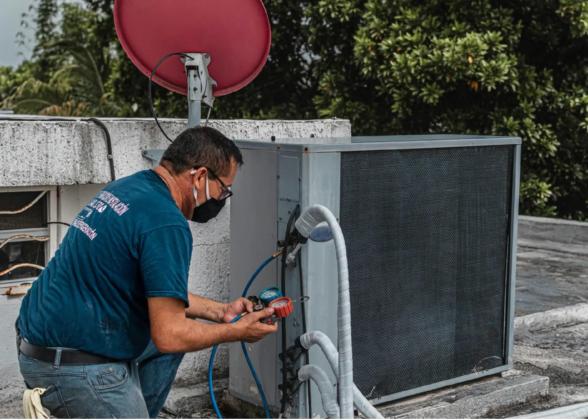 Technician checking refrigerant pressure on an outdoor condenser